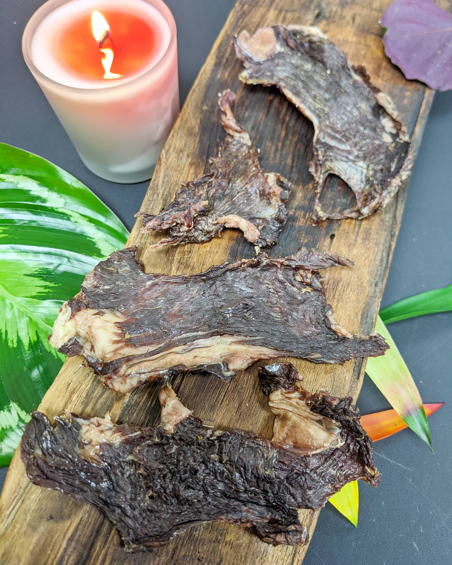 Image of bison pieces on a piece of wood with a candle in the background