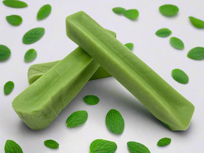 Image of three green mint yak chews on a white background with mint leaves 