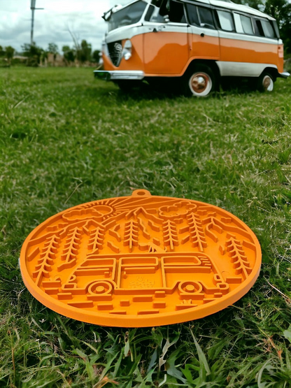 Image of an orange lick mat with a van, mountains and sky setting. 