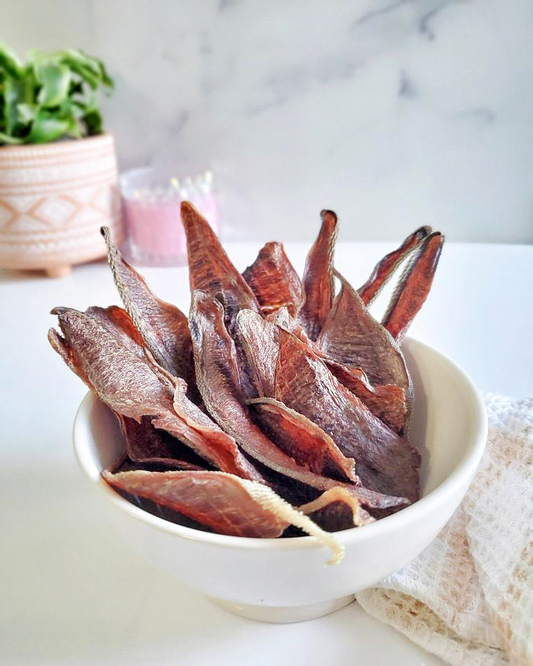 Image of several pieces of beef tongue in a white bowl on a white surface