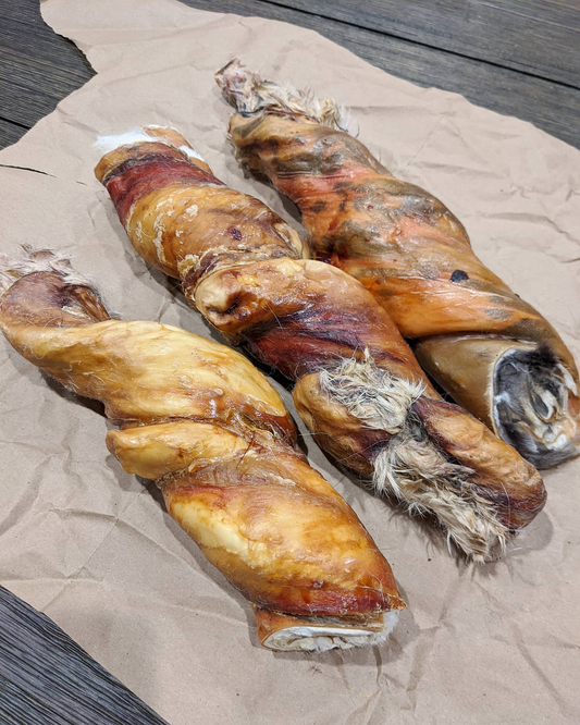 Image of three bunny baguette rolls on light brown paper on a wood surface