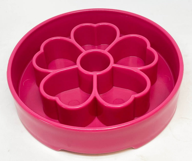 a pink slow feeder bowl with a flower pattern in the middle 