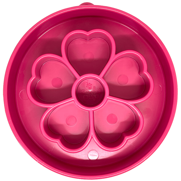 A pink slow feeder bowl with a flower pattern in the middle 