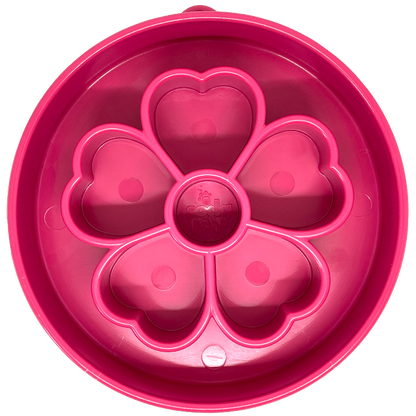 A pink slow feeder bowl with a flower pattern in the middle 