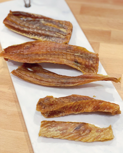 Image of hoki pieces on a white plate with a light wood background