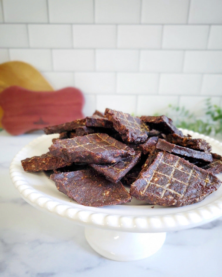 Image of venison pieces on a white plate with a white background 