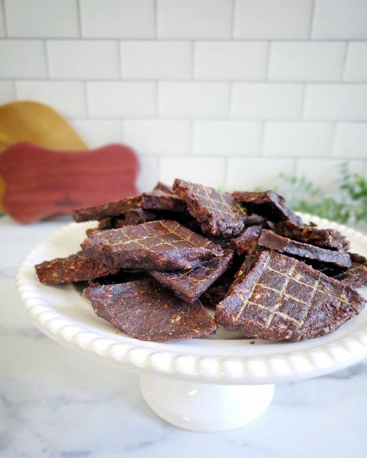 Image of venison pieces on a white plate with a white background 